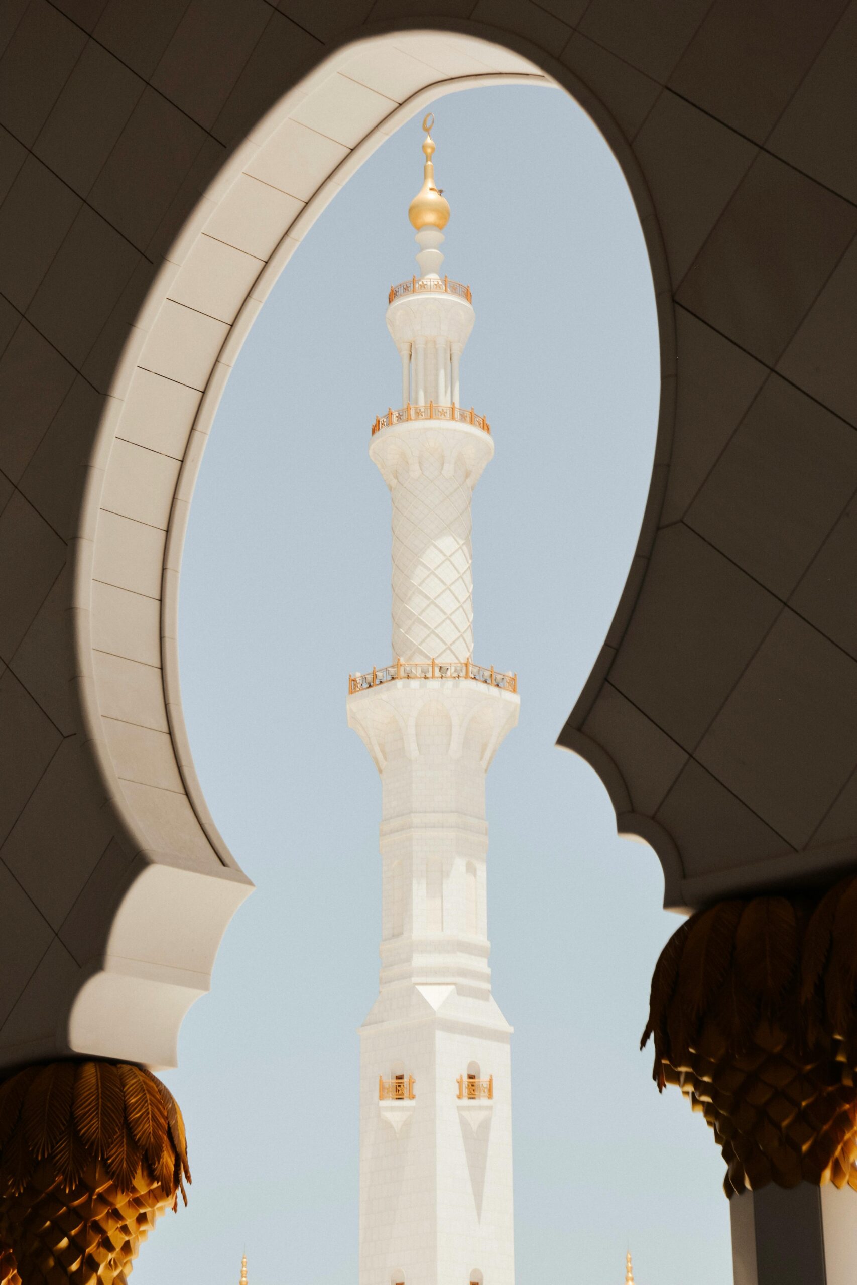 Stunning view of a minaret framed by an ornate mosque archway in Abu Dhabi.